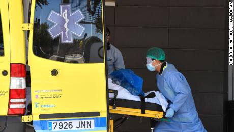 A healthcare worker carries a patient out of an ambulance outside the Arnau de Vilanova University Hospital in Lleida on July 4, 2020. - Spain&#39;s northeastern Catalonia region locked down an area with around 200,000 residents around the town of Lerida following a surge in cases of the new coronavirus.